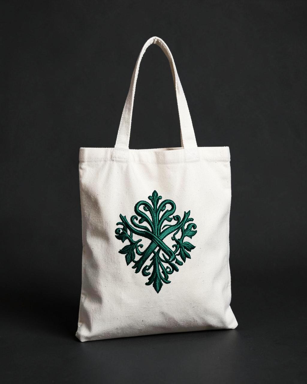 Ivory canvas tote bag with a deep emerald embroidered emblem